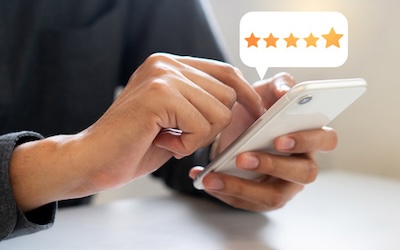 close up on man hand press on smartphone screen with gold five star rating feedback icon and press level excellent rank for giving best score point to review the service , technology business